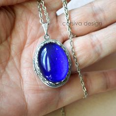 This beautiful locket is adored with a large 18x25 Ruby Red Green glass gem stone. Size: 24x30mm Chain Length: Per Option Qty: 1pc Personalized Blue Jewelry, Personalized Blue Metal Jewelry, Oval Metal Locket Necklace As Gift, Sapphire Cabochon Jewelry As A Gift, Blue Personalized Metal Jewelry, Blue Oval Pendant Jewelry As Gift, Blue Handmade Jewelry For Keepsake, Handmade Blue Jewelry For Keepsake, Oval Blue Jewelry As A Gift