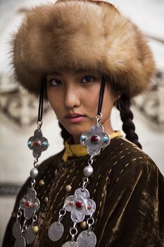 a woman wearing a fur hat and jewelry