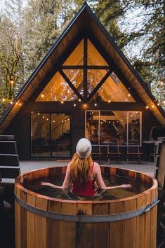 a woman sitting in a wooden hot tub