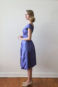 "Vintage 1960's Violet / Blue Satin Party Dress with Asymmetrical pleats. Fit & Flare style with a short cap sleeve Dress has heavy interfacing and a horsehair hem, giving a thick sturdy feel. The dress does have some water damage on the front, though it is not noticeable until close inspection. Measurements Shoulders: 16.5\" / Sleeves: 35\" / Bust: 32'' / Waist: 24.5'' / Hip: free / Length Shoulder to Hem: 42'' Model Measurements: Bust: 33\" / Waist: 24.5\" / Hip: 37\" / Height: 5'6\" - 5'7 Retro Short Sleeve Evening Dresses, 1950s Style Short Sleeve Party Dresses, 1950s Short Sleeve Evening Dresses, 1950s Style Short Sleeve Evening Dresses, Satin Party Dress, Cap Sleeve Dress, Most Beautiful Dresses, Vintage Gowns, Vintage Bridal