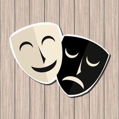 two masks with faces drawn on them sitting next to each other