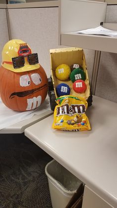 an office cubicle decorated for halloween with candy and pumpkins