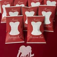 six bags of red and white wedding favors