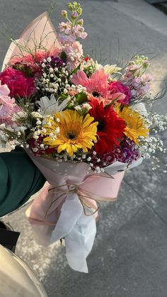 a bouquet of flowers tied to the handle of a scooter