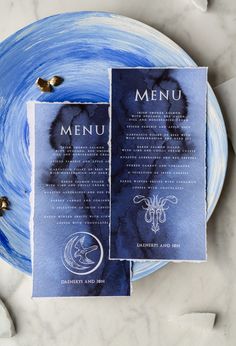 two menus sitting on top of a blue plate