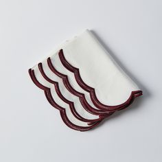 four napkins with red and white wavy designs on them, sitting next to each other