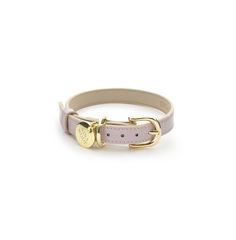 a pink leather dog collar with gold hardwares and a heart charm on the front