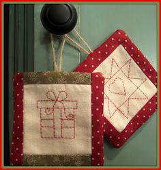 two red and white quilts hanging on a doorknob with a black knob