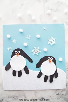 two penguins are standing next to each other in front of snowflakes and scissors