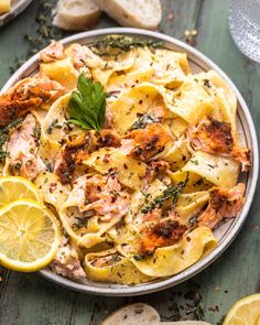 a plate full of pasta with chicken and lemon slices