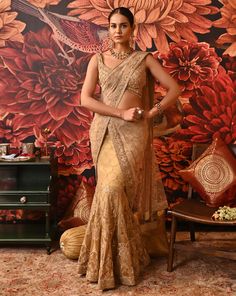 This authentic Layla saree is a one-of-a-kind attire that exudes glamour and modernity. The fishtail drape on the skirt adds a contemporary twist to your classic saree. The vivid embroidery details highlighted with beads are fascinating along with the attached sheer pallu. The sleeveless blouse is heavily accentuated with beads and sequins. A great show-stealer with a style so surreal. Heavily embellished cross-band sleeveless gold-foil printed blouse with centre back hook opening Fish-cut Saree with embroidered applique work with dabka and nakshi at the border of the pallu Side zip closure in the saree. From Moledro’s Riwayat collection. DELIVERY TIMEPlease allow 8-12 weeks for your outfit to arrive. FABRIC DETAILSSaree - Butterfly Net, Zari BrocadePallu - Butterfly NetBlouse - Cotton Sil Elegant Dola Silk Pre-draped Saree With Resham Embroidery, Designer Wear Pre-draped Saree With Self Design For Navratri, Floor-length Saree With Sheer Dupatta For Reception, Elegant Pre-draped Saree With Dupatta For Festivals, Designer Art Silk Pre-draped Saree With Zari Work, Bollywood Style Art Silk Pre-draped Saree With Sheer Dupatta, Fitted Pre-draped Saree With Zari Work For Wedding, Elegant Dola Silk Saree Set, Dola Silk Pre-draped Saree With Sheer Dupatta For Diwali