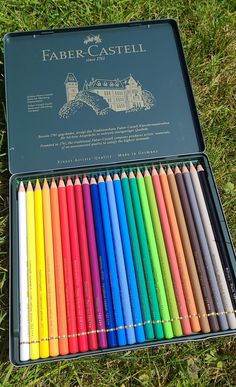 a box of colored pencils sitting in the grass