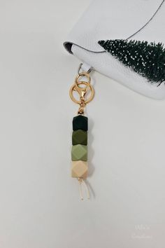 a keychain with a green, beige and black bead hanging from it