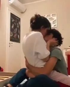 two people hugging each other in the living room