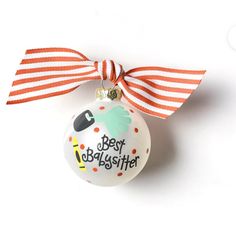 a white ornament with a red and white striped ribbon