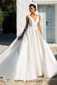 a woman in a white wedding dress standing outside