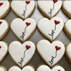 heart shaped cookies with the words we love you written on each cookie, arranged in rows