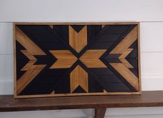 a wooden frame sitting on top of a table next to a wall mounted clock with an arrow design