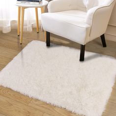 a white chair sitting on top of a hard wood floor next to a book shelf