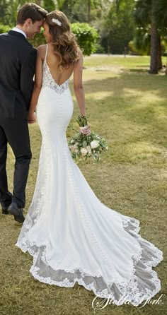 a bride and groom standing in the grass