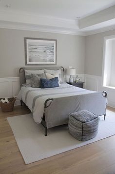 a bedroom with a bed, rug and two baskets on the floor in front of it