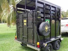 the trailer is parked in the grass with its door open to allow people to load their belongings