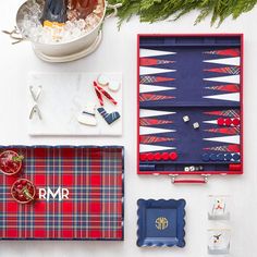 an assortment of personal items laid out on top of a table with pine branches in the background