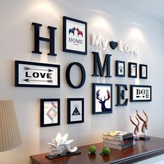 a white dresser topped with lots of pictures and framed art on the wall next to a lamp