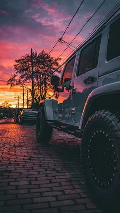 a jeep parked on the side of a road at sunset