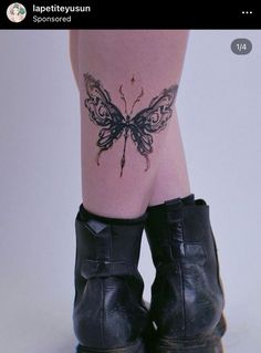 a tattoo on the leg of a woman's legs with a butterfly tattooed on it