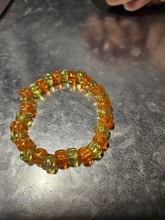 This orange and green beaded bracelet is fun for everyone! Great for parties, concerts and more! Green Stretch Bracelet With Colorful Beads For Party, Handmade Orange Stretch Bracelet With Round Beads, Handmade Orange Bead Stretch Bracelet, Casual Adjustable Stretch Bracelet For Party, Green Round Beads Stretch Bracelet For Party, Green Stretch Bracelet With Round Beads For Party, Yellow Beaded Bracelet For Party, Orange Stretch Bracelet With Large Beads As Gift, Handmade Orange Beaded Bracelets For Party