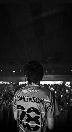 a man standing in front of a crowd at a concert with his back to the camera