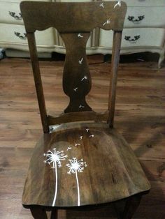 a wooden chair with white flowers painted on it