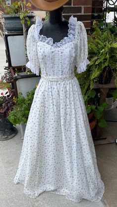 For sale today is a fabulous Gunne Sax formal dress. This dress features small floral print of hyacinth or lavender and roses. The dress features an over skirt of sheer cotton over a polyester slip topping a Crinoline slip underneath give me this fabulous dress shape, form, and whimsy. The dress is made with a sweetheart neckline and puffed half sleeves, all trimmed in lace. The bodice has rows of lace coming down the front, the dress is nipped in the waist, and finished with a wide sash. The dress is in excellent vintage condition, there are no issues, it is ready to be worn and styled in your cottagecore Instagram post. Crinoline Skirt, Slip Top, Gunne Sax, Peasant Dress, Fabulous Dresses, Lace Bodice, Dress Shapes, Sweetheart Neckline, Half Sleeves