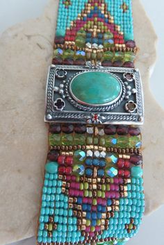 Chili Rose Beaded Turquoise & Gemstone Bracelet by Adonnah Langer of Santa Fe, New Mexico Gorgeous Diana Bracelet features a Southwestern blend of turquoise, olive green and red Swarovski beads handcrafted with a true artistic mix of beads and a canvas of gorgeous colors. Center Medallion features an array of semi-precious stones *Medallion measures 1 1/4 inch x 7/8 inch Santa Fe Jewelry Artist, Adonnah Langer has been designing distinctive wearable art for over two decades Stripes of Czech Southwestern Green Jewelry With Spacer Beads, Green Southwestern Jewelry With Spacer Beads, Handmade Southwestern Green Beaded Bracelets, Southwestern Style Green Jewelry With Spacer Beads, Handmade Green Southwestern Beaded Bracelets, Artisan Green Handmade Bracelets, Handmade Southwestern Green Bracelets, Southwestern Green Beaded Bracelets For Festival, Southwestern Green Bracelets For Festival