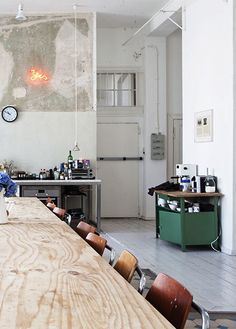 a long table in a room with lots of counter space and stools around it