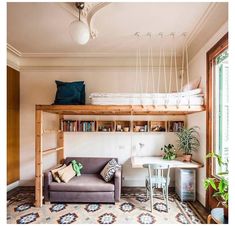 a living room with a couch, desk and bookshelf above the bunk bed