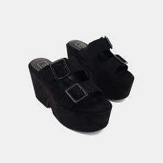 This striking black wedge platform sandal is crafted from luxurious suede and faux leather, offering both style and sophistication. The double buckle straps add an edgy flair, while the molded footbed guarantees unmatched comfort. With its bold platform, this sandal is designed to make a statement, ensuring you stand out effortlessly while enjoying all-day wear. Black Wedge, Black Wedge Sandals, Loafer Mules, Graceland, The Double, Sneaker Heels, Platform Wedges, Mule Clogs, Boot Sandals