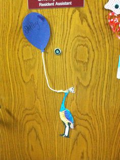 a bulletin board with an image of a blue bird holding a balloon attached to it