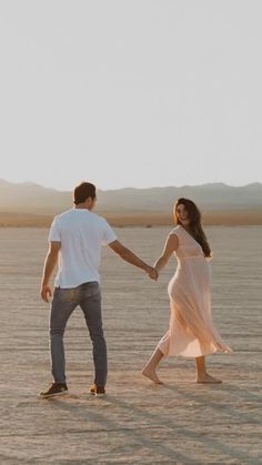 a man and woman holding hands in the desert