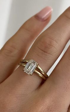 a woman's hand with a ring on it and a diamond in the middle