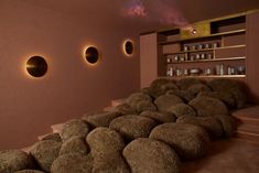 a room that has some round lights on the wall and rocks in front of it