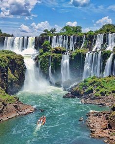 a boat is in the water near a large waterfall with two people riding on it