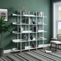 a living room with green walls and white shelving