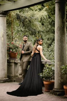 a man and woman in formal wear standing next to each other on a brick patio