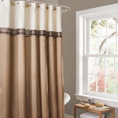 a white shower curtain with black trim in a bathroom next to a bathtub and window