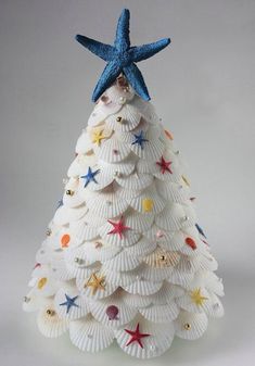 a christmas tree made out of seashells with a star on top