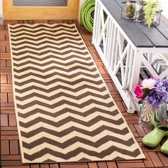 a brown and white rug sitting on top of a wooden floor next to green shoes