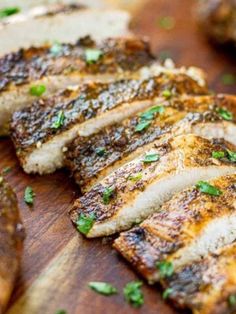 grilled pork chops on a cutting board with parsley sprinkled on top