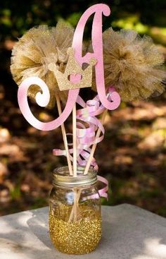 there is a mason jar with some flowers in it and the letter d on top